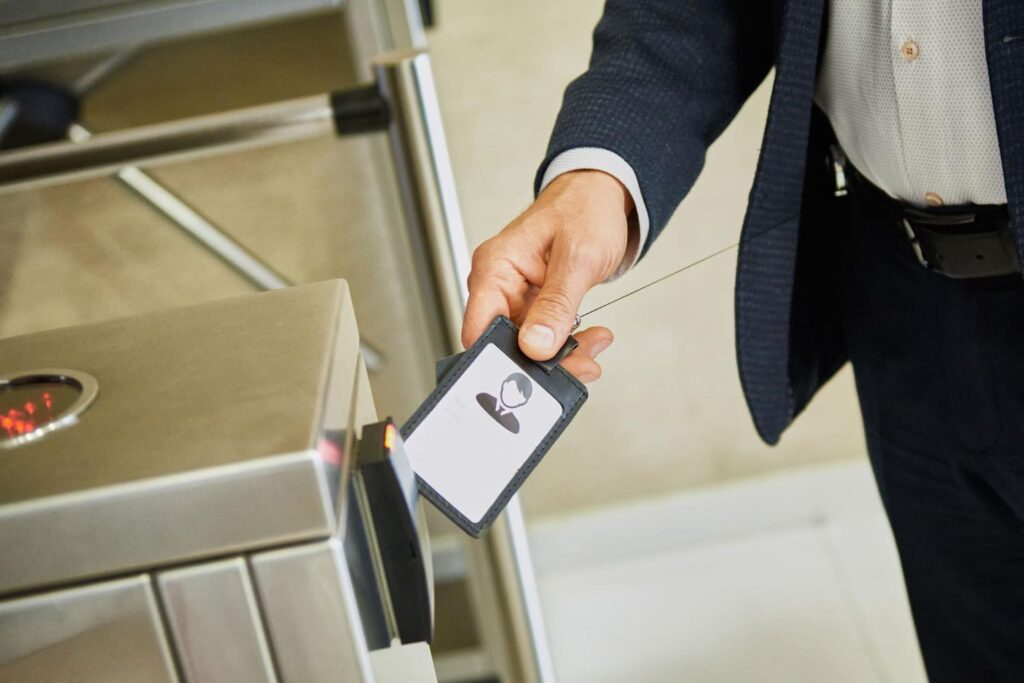 A man using an electronic pass to go through a turnstile